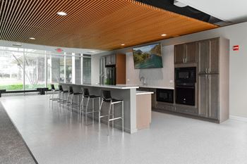 A modern kitchen with a long island and stainless steel appliances.